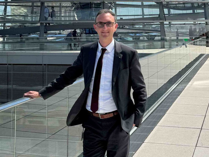 Alexander Jordan vor der Kuppel des Bundestages.