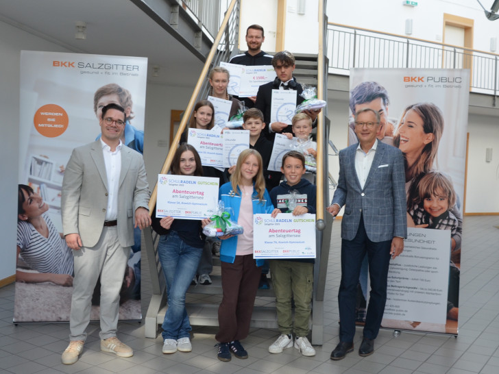 Lehrer Xaver Wiese vom Kranich-Gymnasium (hinten oberste Treppenstufe), BKK-Vorstand Matthias Frenzel (rechts) und Dr. Marcel Dierich (links, BKK Bereich Gesundheitsförderung) mit den Lebenstedter Siegerinnen und Siegern des Schulradeln 2025. 1. Reihe von links nach rechts: Anastasia Sorocean, Finja Urbas, Mattis Treutheit; 2. Reihe von links nach rechts: Lisbeth Scholz, Elias Poloczek, Luca Gruner, 3. Reihe Anabel Metze und Manuel Deimling. 
