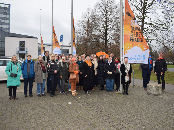 Gruppenbild auf dem Rathausvorplatz beim Hissen der orangen Flagge.
