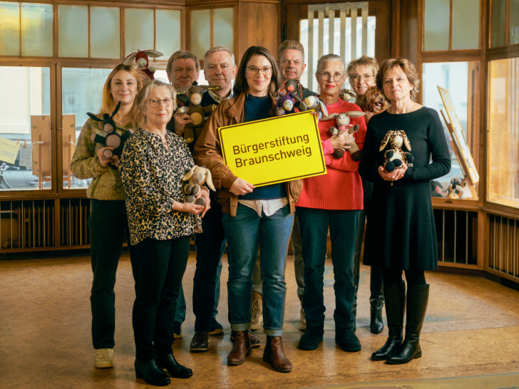 Maria Meibohm (mit Schild, Buchhandlung Graff) steht gemeinsam mit Ehrenamtlichen der Bürgerstiftung Bürgerstiftung im zukünftigen MitMachEck der Stiftung. In den Händen halten die Ehrenamtlichen selbstgenähte Esel, die das Projekt „LEsel unterwegs – Die Rucksackbibliothek“ unterstützen.