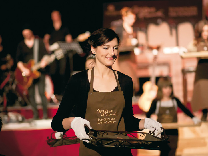 Die Schokoladen-Botschafter servieren während des Konzerts die live auf der Bühne zubereiteten Schokoladen-Pralinen.