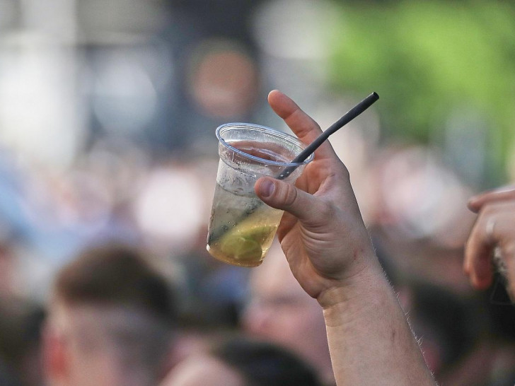 Ein Mann hält ein alkoholisches Getränk hoch (Archiv)