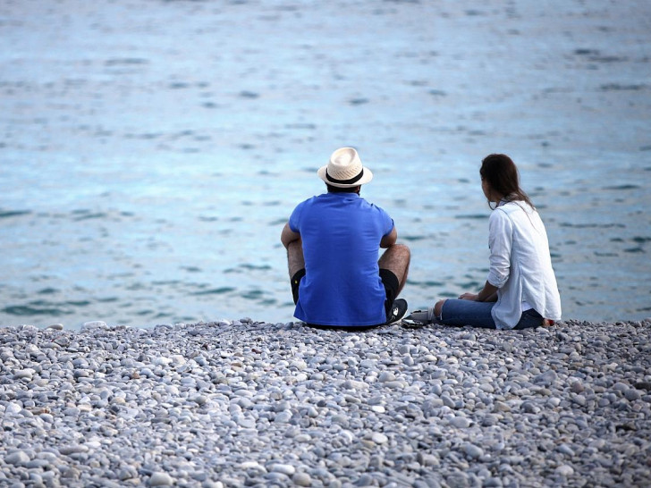 Mann und Frau sitzen am Strand