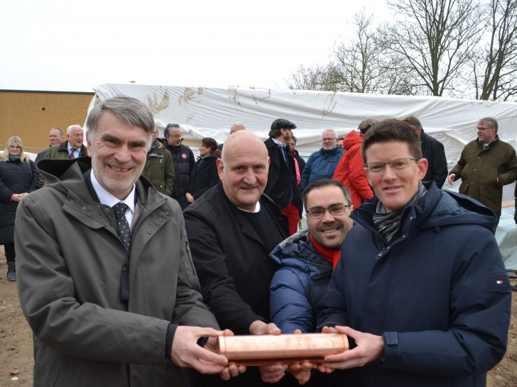 Von links nach rechts: Landrat Henning Heiß, Thomas Wenzig (Architekt), Jochen Schmidt (Vorsitzender MTV Vechelde) und Bürgermeister Tobias Grünert mit der Zeitkapsel, die in den Anbau einbetoniert werden soll.