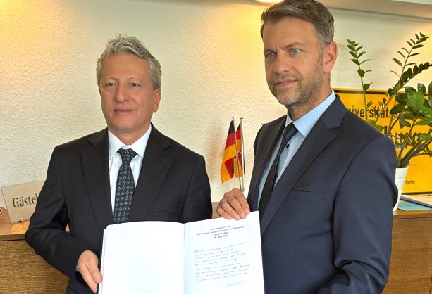 Eintrag ins Gästebuch: Generalkonsul Yusuf Arikan mit Oberbürgermeister Dennis Weilmann (rechts). 