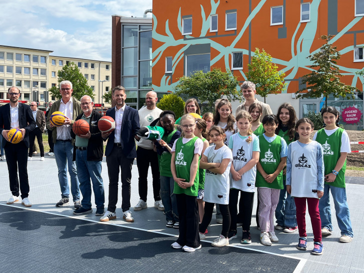  Eröffnung der 3x3-Basketballanlage in der Wolfsburger Innenstadt, v. l. Wirtschaftsdezernent und WMG-Geschäftsführer Jens Hofschröer, Ratsvorsitzender Ralf Krüger, Ortsbürgermeister Erich Schubert, Oberbürgermeister Dennis Weilmann sowie Spielerinnen und Trainerstab der Mädchen-Basketballmannschaft des VfL Wolfsburg e.V.