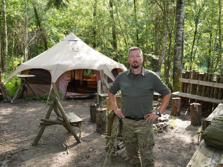 Stefan Winkler vor dem Gruppenzelt in seinem Survivalcamp.