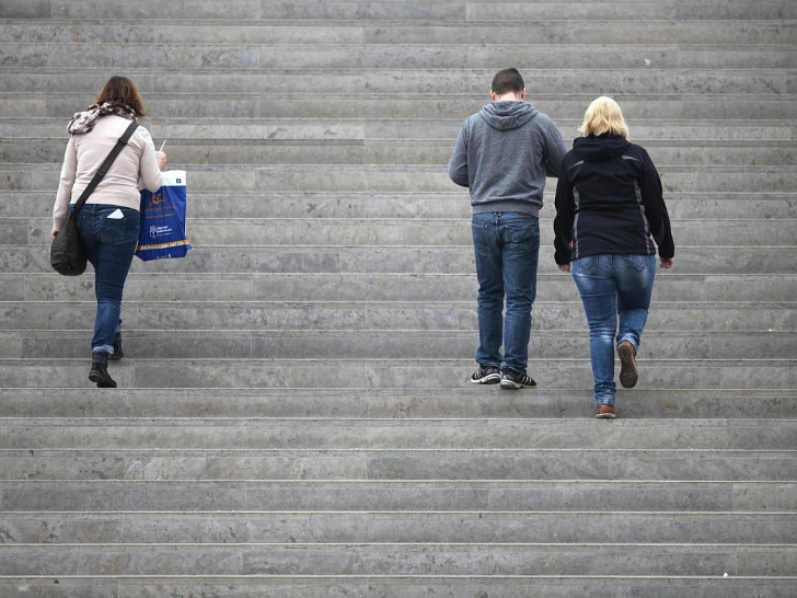Drei Personen gehen eine Treppe hinauf (Archiv)
