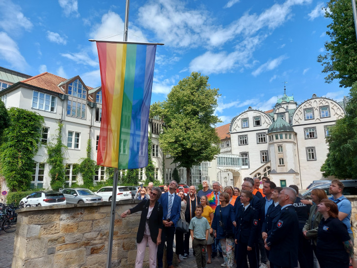 Erster Kreisrat Dominik Meyer zu Schlochtern, Vertreterinnen und Vertreter des Queeren Netzwerks Gifhorn und zahlreiche Gäste hissten die Regenbogenflagge vor dem Schloss Gifhorn.