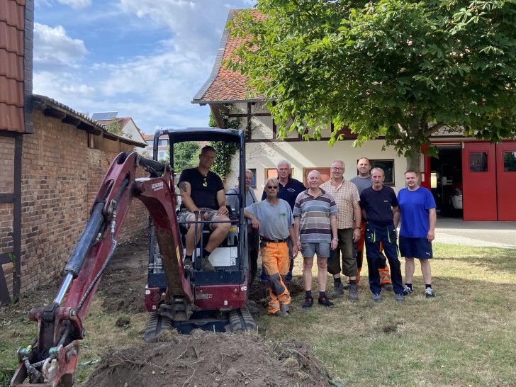 Erster Spatenstich für das Kleine Spritzenhaus: Im Bagger Ortsbrandmeister Matthias Hartlich, dann weiter von links Jens und Christian Behrens, Henning Plumeyer, Helge Michler, Frank Oesterhelweg, Simon Gloger, Bernd Isaak und Tim Helbig.