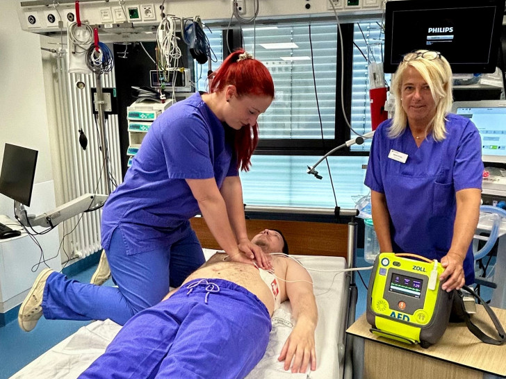 Linda Baumgarten (v. li.) und Marion Kruse (beide Fachschwestern Anästhesie- und Intensivmedizin) demonstrieren an einem Kollegen eine simulierte Reanimation mit einem AED.