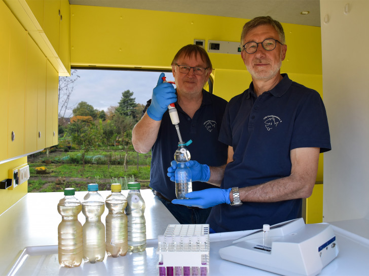 Arno Mittelmeyer und Heinz-Theo van Wickeren untersuchen eine Brunnenwasserprobe im Labormobil des VSR-Gewässerschutz e.V..