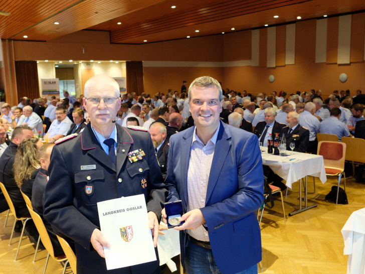 Landrat Dr. Alexander Saipa verleiht dem scheidenden Kreisbrandmeister des Landkreises Goslar die Ehrenmedaille des Landkreises Goslar. Den Rahmen bildete die Delegiertenversammlung der Kreisfeuerwehr.