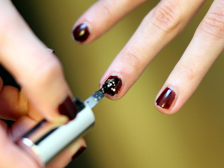 Frau lackiert Fingernägel mit Nagellack (Archiv)