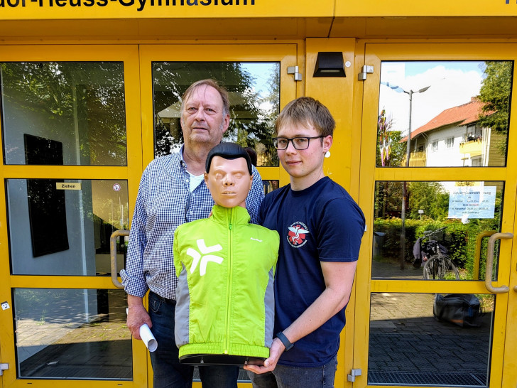 Stephan Pinkert und David Kröger präsentieren die neu erhaltene Reanimationspuppe, mit der THG-Schülerinnen und Schüler zukünftig in Wiederbelebungsmaßnahmen geschult werden können.