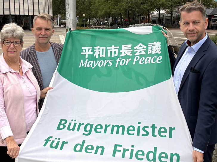 Oberbürgermeister Dennis Weilmann (rechts) sowie Bürgermeisterin Angelika Jahns und Bürgermeister Andreas Klaffehn hissten auf dem Rathausplatz Flaggen für den Weltfrieden.