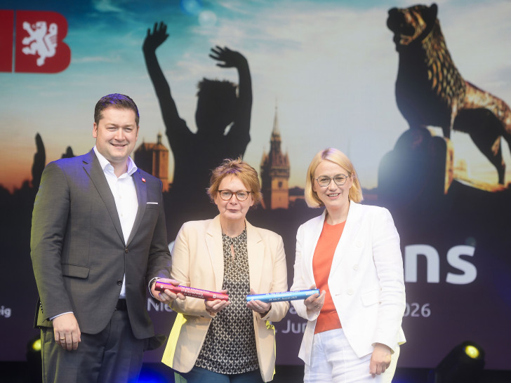 Die Niedersächsische Ministerin für Inneres, Sport und Digitalisierung, Daniela Behrens (Mitte), übergibt im Beisein von Osnabrücks Oberbürgermeisterin Katharina Pötter den Staffelstab an Oberbürgermeister Dr. Thorsten Kornblum.