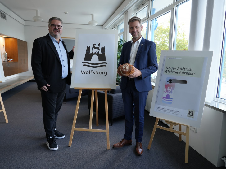 Oberbürgermeister Dennis Weilmann und Lars Vollmering, Leiter der strategischen Kommunikation, präsentieren das neue Logo der Stadt Wolfsburg.