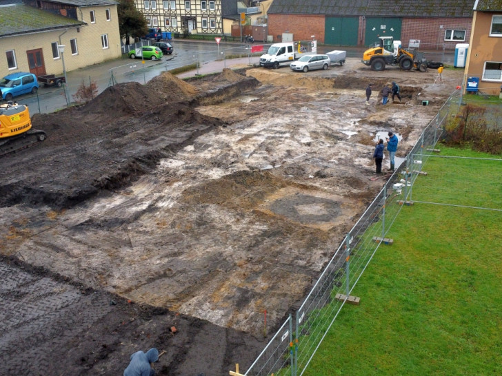  Das Baufeld im Ortskern von Ehra-Lessien mit der Verfärbung eines Holzkastenbrunnens im Vordergrund.