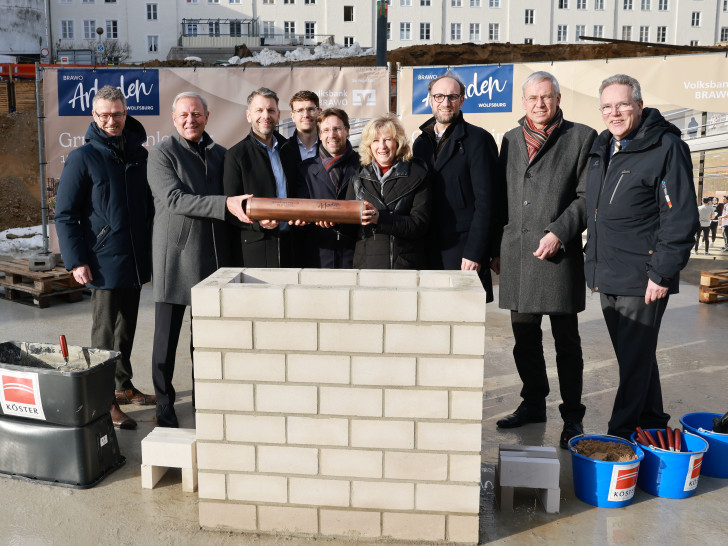 Grundsteinlegung am 15. Januar 2026 mit Zeitkapsel: André Triphaus-Woltermann (Geschäftsführer und technischer Vorstand der Köster Holding SE), Jürgen Brinkmann (Vorstandsvorsitzender der Volksbank BRAWO), Dennis Weilmann (Oberbürgermeister), Benjamin Maspohl (Projektentwickler der BRAWO RE Development Braunschweig), Sebastian Geese (Bereichsleiter Hochbau Braunschweig der Köster GmbH), Claudia Kayser (Leiterin der Direktion Wolfsburg der Volksbank BRAWO), Jens Hofschröer (Stadtrat und Dezernent für Digitales und Wirtschaft), Kai-Uwe Hirschheide (Erster Stadtrat und Stadtbaurat) und Ulf Müller (Geschäftsführer BRAWO RE Building Solutions). In der Zeitkapsel befindet sich eine Tageszeitung, Baupläne der BRAWO Arkaden, Polaroidfotos vom Eventtag sowie Impressionen und ein Poetry-Slam-Text vom 100-jährigen Jubiläum der Volksbank in Wolfsburg vom 6. November 2025.