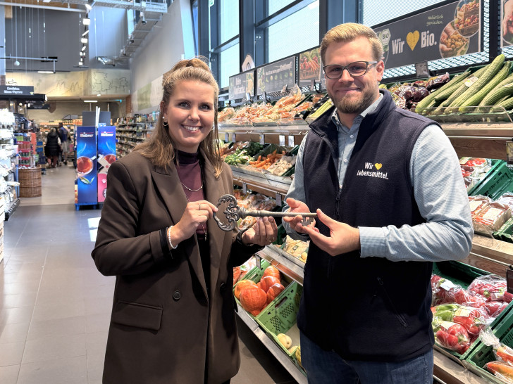 Julia Ogiermann übergibt den symbolischen Schlüssel an Rolf Kruse, den neuen Marktleiter des Edeka Centers in der Allerstraße. 