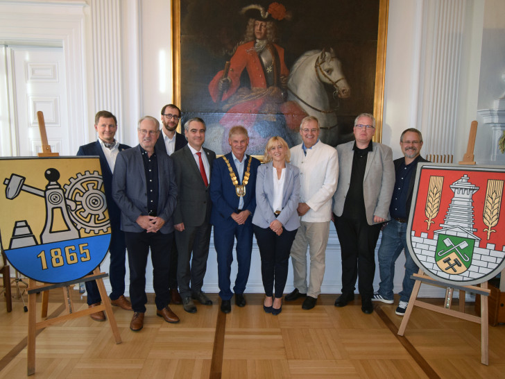 : Zwischen den Stadtwappen von Kattowitz (l.) und der Stadt Salzgitter (r.): v.l.  Maksymilian Michalek, Gunter Kostorz, Jacek Malcher, Stephan Rauhut, Oberbürgermeister Frank Klingebiel, Sarah Krieger, Heiko Schmelzle, Christoph Lücke, Arne Homann.