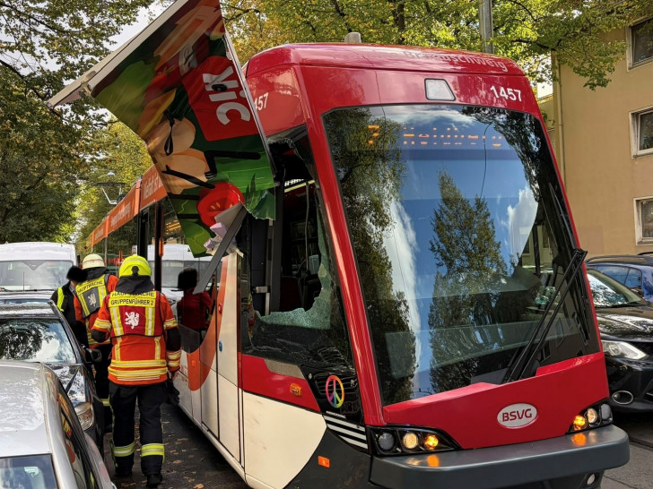 Straßenbahn mit abgerissenem Seitenteil des Lieferfahrzeugs.