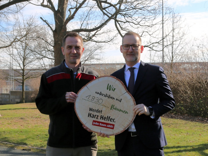 Michael Vogler (Volksbank BRAWO, Foto rechts) überreicht Cord Meinecke von den Niedersächsischen Landesforsten symbolisch die 1.830 Bäume für die Aufforstung im Harz.
