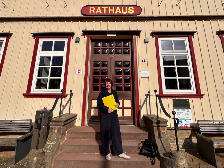 Anja Morell hält vor dem Seesener Rathaus die Unterstützer-Unterschriften in der Hand.