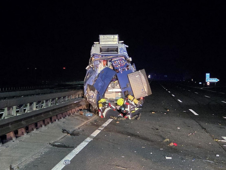 Die Feuerwehr unter Atemschutz an einem beschädigten Fahrzeug (Archiv)