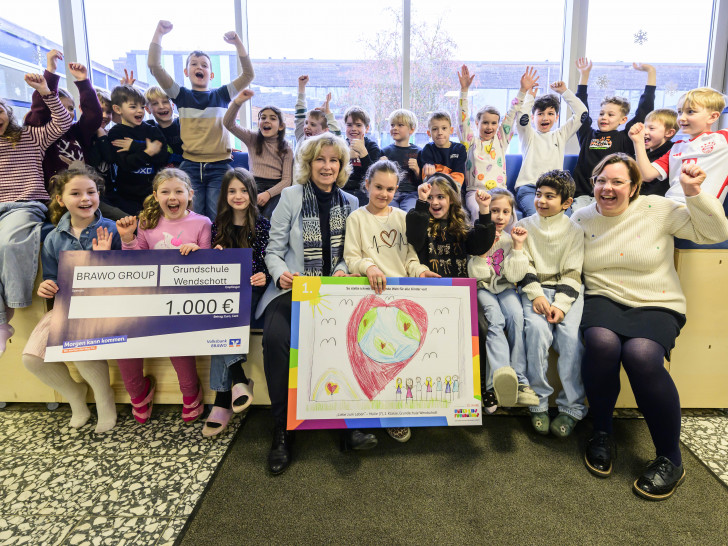 Claudia Kayser, Direktionsleiterin Wolfsburg der Volksbank BRAWO und Botschafterin von United Kids Foundations, überreichte Malie von der Grundschule Wendschott im Beisein ihrer Klasse ihr Gewinnerbild auf Leinwand sowie einen Scheck für die Klassenkasse