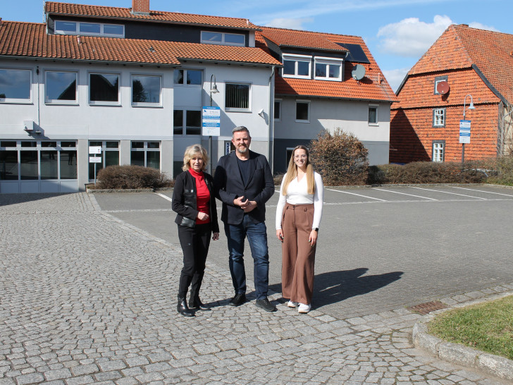 Claudia Kayser (Leiterin der Direktion Wolfsburg der Volksbank BRAWO), Andreas Busch (Bürgermeister der Gemeinde Lehre) und Lara Höthke (Mitarbeiterin im Bereich Liegenschaften bei der Volksbank BRAWO) auf dem Parkplatz der Volksbank BRAWO in Lehre (v. li.).