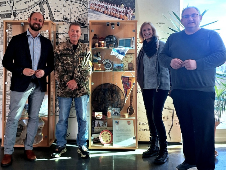 Bürgermeister Malte Schneider (li.) und die Vertreter des PVS an der Partnerschaftsvitrine im Schöninger Rathaus. Die Souvenirs erinnern an die Reisen und Besuche in friedlichen Zeiten: Vereinsvorsitzender Peter Voß, Marita Soltysiak und Jan Fricke.