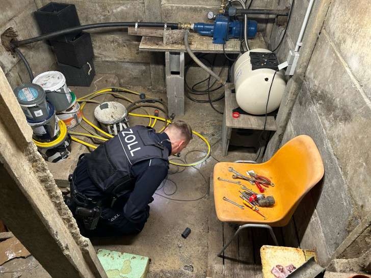 Zöllner bei der Durchsuchung eines Kellers einer Gartenhütte auf dem Grundstück der einen Beschuldigten.