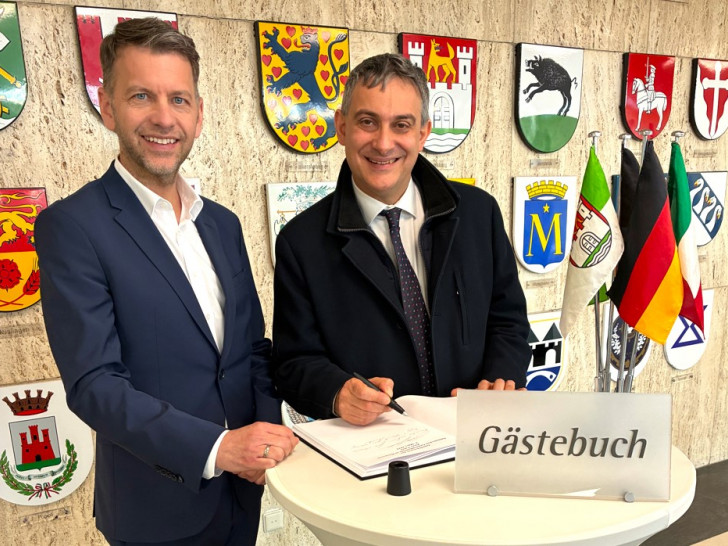 Im Beisein von Oberbürgermeister Dennis Weilmann trägt sich Generalkonsul Piero Vaira (rechts) in das Gästebuch der Stadt ein.