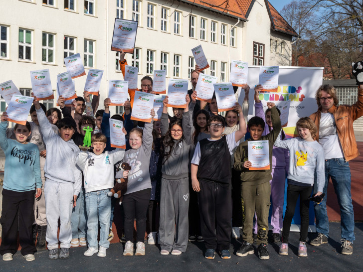 Die Klasse 4c freut sich über ihren Pokal und die von Nicole Mölling (hi. Mitte), Direktionsleiterin Volksbank BRAWO Salzgitter, überreichten Urkunden. 