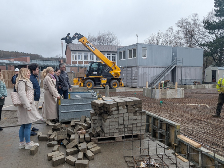 Gerade entsteht noch die Bodenplatte der Grundschule Oker – ab nächster Woche startet dann der Modulbau. Daniel Gintaut (2. v. re.) vom GGM erklärt Schulleiterin Claudia Kohl (3. v. re.) und Oberbürgermeisterin Urte Schwerdtner (4. v. re.) die Baustelle.