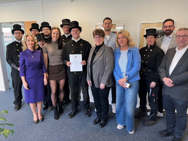 Bezirksschornsteinfeger Tim Robin Smolka im Kreis seiner Schornsteinfegermeisterkolleginnen und -kollegen, seiner Familie und von Vertretern der Kreisverwaltung.