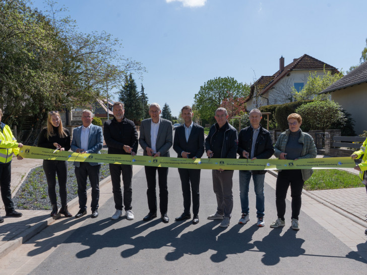 Oberbürgermeister Dennis Weilmann (fünfter von links), Erster Stadtrat und Stadtbaurat Kai-Uwe Hirschheide (vierter von links) und Vertretern der Verwaltung und Politik bei der offiziellen Freigabe der Straße Alexanderberg. 