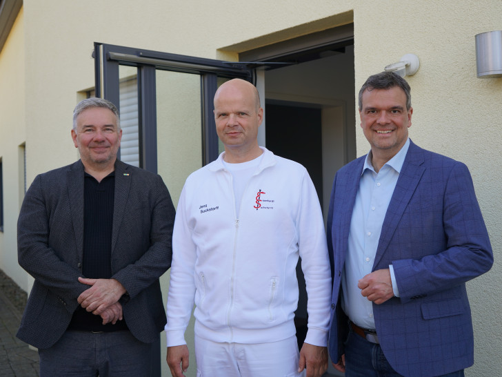 Jens Suckstorff (Mitte) erhält von Landrat Dr. Alexander Saipa (rechts) und Frank Dreßler eine Förderung aus dem Programm für die Ansiedlung von Ärztinnen und Ärzten.