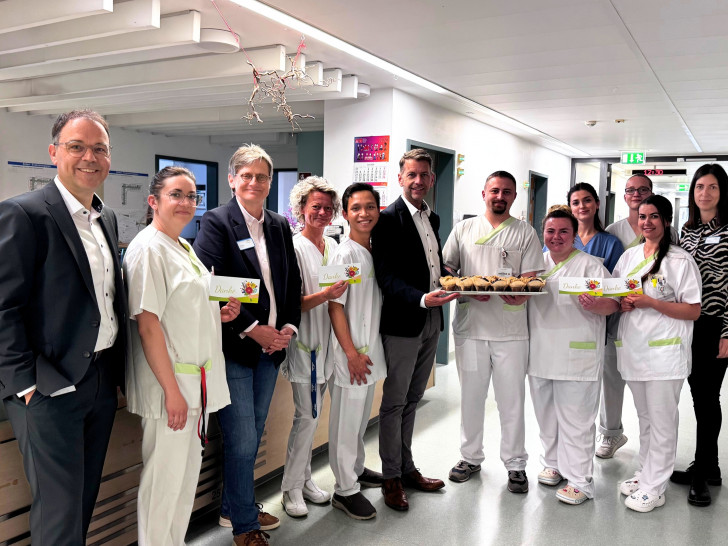 (von links) Der stellvertretende Klinikumsdirektor Jörg Reinhardt, Pflegedirektorin Christiane Bitter, Wolfsburgs Oberbürgermeister Dennis Weilmann, und Lynn Erle aus dem Team Pflegedirektion verteilten anlässlich des Internationalen Tages der Pflegenden süßes Gebäck an die Mitarbeitenden auf den Stationen und in den Funktionsbereichen des Klinikums. Das Foto zeigt sie gemeinsam mit dem Team der Station G6a.