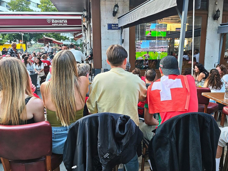 Fans und Interessierte schauen in einer Bar in Genf Fußball