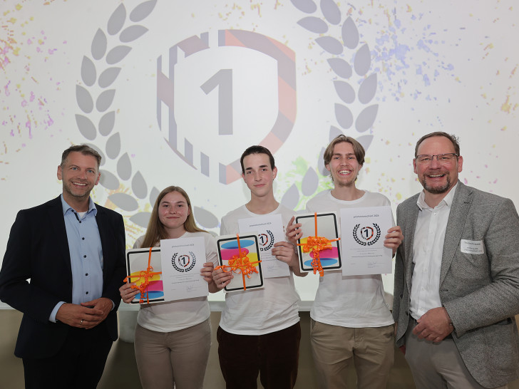 Das Team Future Minds der BBS Goslar-Baßgeige/Seesen sichert sich den ersten Platz bei promotionschool 2026. Mit ihrer Geschäftsidee "Second Soul – Herstellung funktionaler Designprodukte aus alten Erinnerungsstücken" überzeugten sie die Jury durch Innovationskraft und Praxistauglichkeit.  Auf dem Bild: (v.l.) Dennis Weilmann (Oberbürgermeister der Stadt Wolfsburg), Siegerteam, Thomas Krause (Wolfsburg AG)