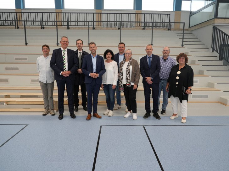 Vertreterinnen und Vertreter aus Verwaltung, Schule und Wolfsburger Schulmodernisierungsgesellschaft bei der Wiedereröffnung der sanierten Dreifeldsporthalle am Schulzentrum Vorsfelde. Mit dabei waren unter anderem Oberbürgermeister Dennis Weilmann (4. v. l.), Stadträtin Iris Bothe (4. v. r.), die Geschäftsführer der Wolfsburger Schulmodernisierungsgesellschaft Christoph Andacht und Marc-Frederik Augath sowie die Schulleitungen des Schulzentrums.