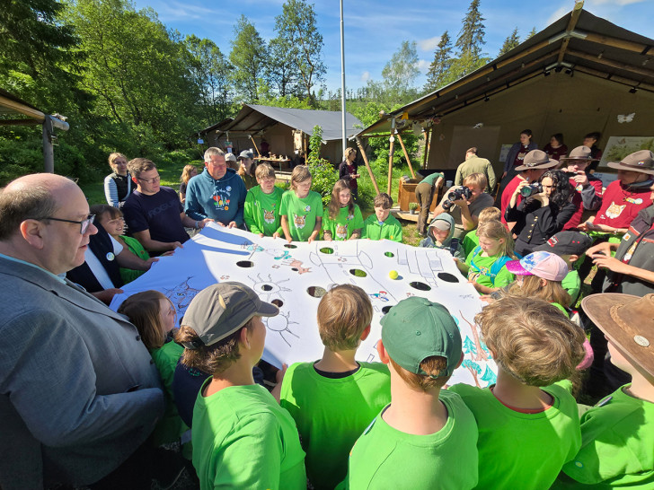 Die Junior-Ranger spielten mit Bundesumweltminister Carsten Schneider (2.v.li. hinten) und dem niedersächsischen Umweltminister Christian Meyer (links vorne) das Spiel "Der Weg des Luchses".