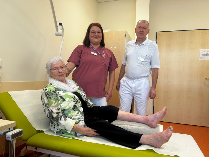 Nur noch eine leichte Färbung deutet auf die ehemals große Wunde am linken Knöchel hin. V.l. Patientin Gisela Zimmermann, Wundexpertin Kristina Weißling, ltd. Oberarzt Oskar Dzumla