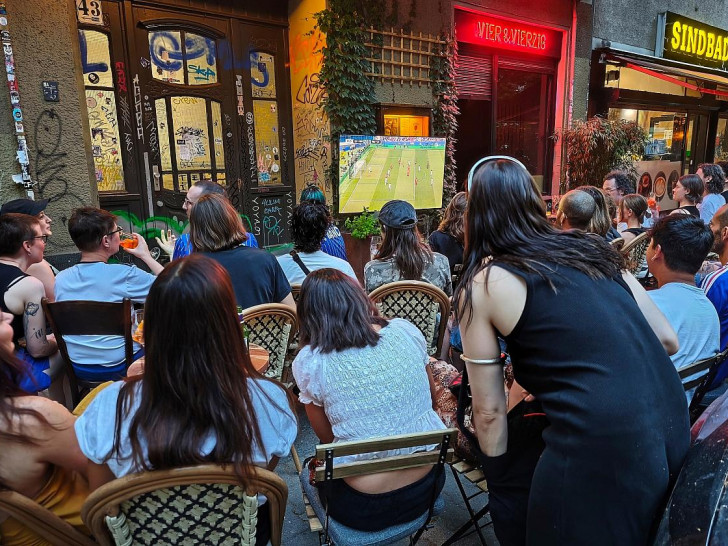 Interessierte schauen auf der Straße Fußball am 26.06.2026