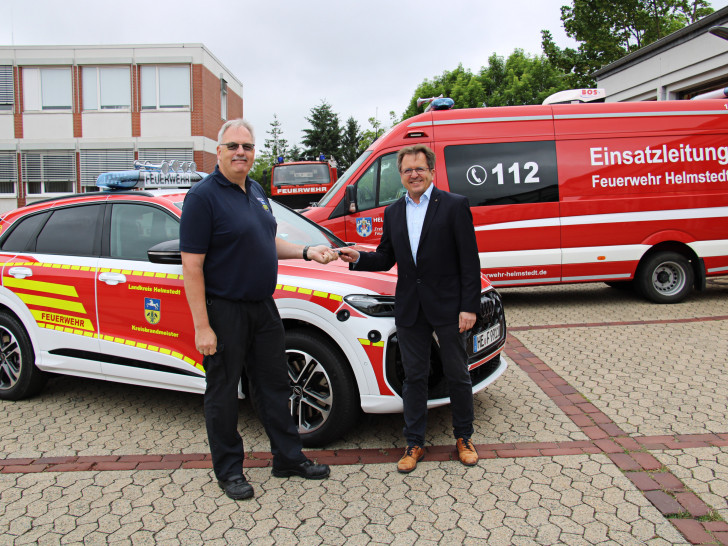 Kreisbrandmeister Maik Wermuth (li.) nimmt die Autoschlüssel von Torsten Wendt entgegen.