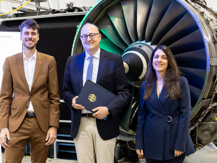 Staatssekretär Matthias Hauer mit dem Vlame Projektleiter Dr.-Ing. Jan Göing und Jun.- Prof. Federica Ferraro vor dem High-Bypass-Turbofan-Triebwerk der TU Braunschweig.