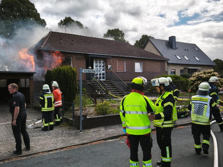 Küche im Vollbrand beim Eintreffen erster Kräfte: Aus beiden Fenstern (links vorn und Seite) schlagen massiv Flammen, Rauch steigt bereits aus dem Dachstuhl.